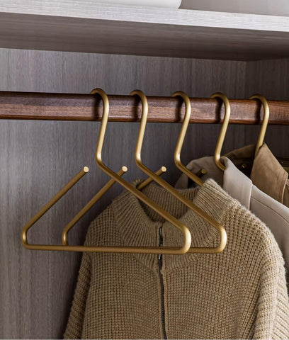 WONQEXZ premium matte gold aluminum hanger closeup showing a smooth surface for delicate fabrics.