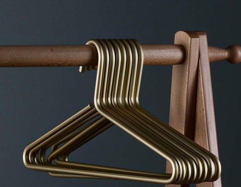 WONQEXZ ultra-slim matte gold aluminum hanger stacked for efficient closet storage.