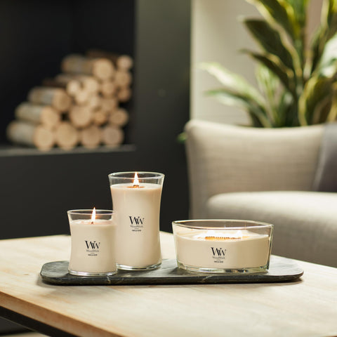WoodWick Vanilla Bean Candle cozy-setting image suggests warm ambience any room.
