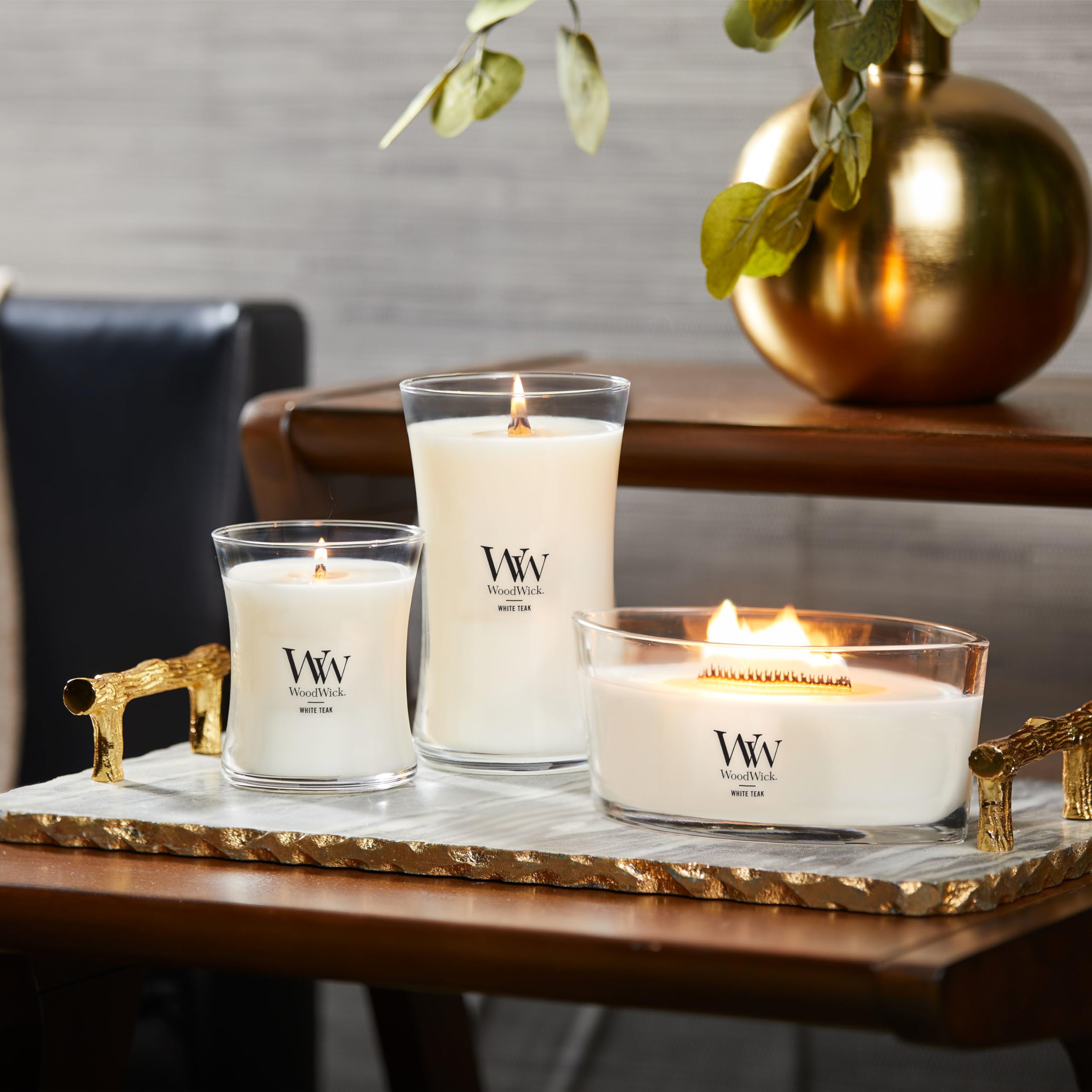 WoodWick White Teak candle lighting a cozy living room.