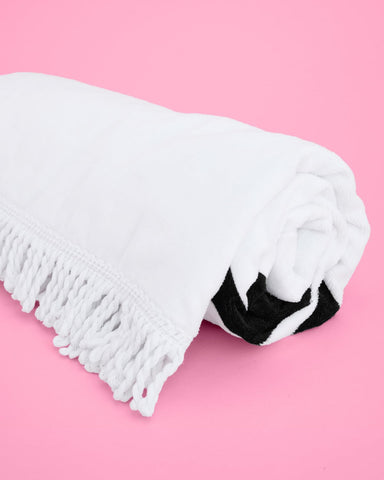 xo Fetti Bride Fringe Beach Towel on poolside chair during sunny day.