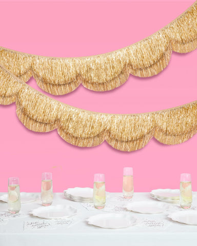 Close-up of gold foil fringe on the xo, Fetti banner captures shimmering mood