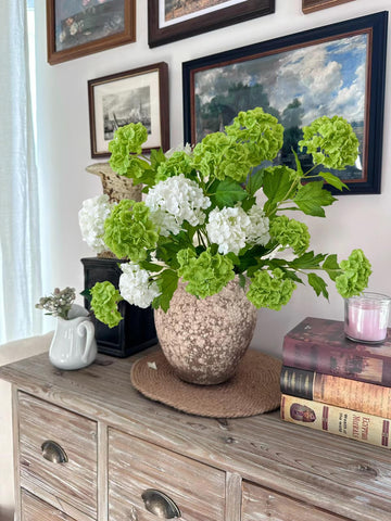 YalzoneMet dark green Snowball Viburnum Hydrangea bouquet look enhances table decor.