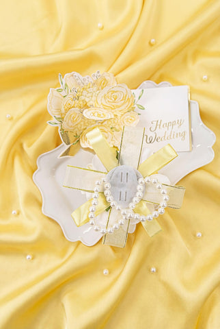 Yelinart pearl-embellished satin ribbon accent on boutonniere.