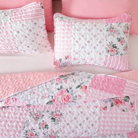 Queen bed styled with YIKUSH quilt, warm floral pattern and inviting drape.