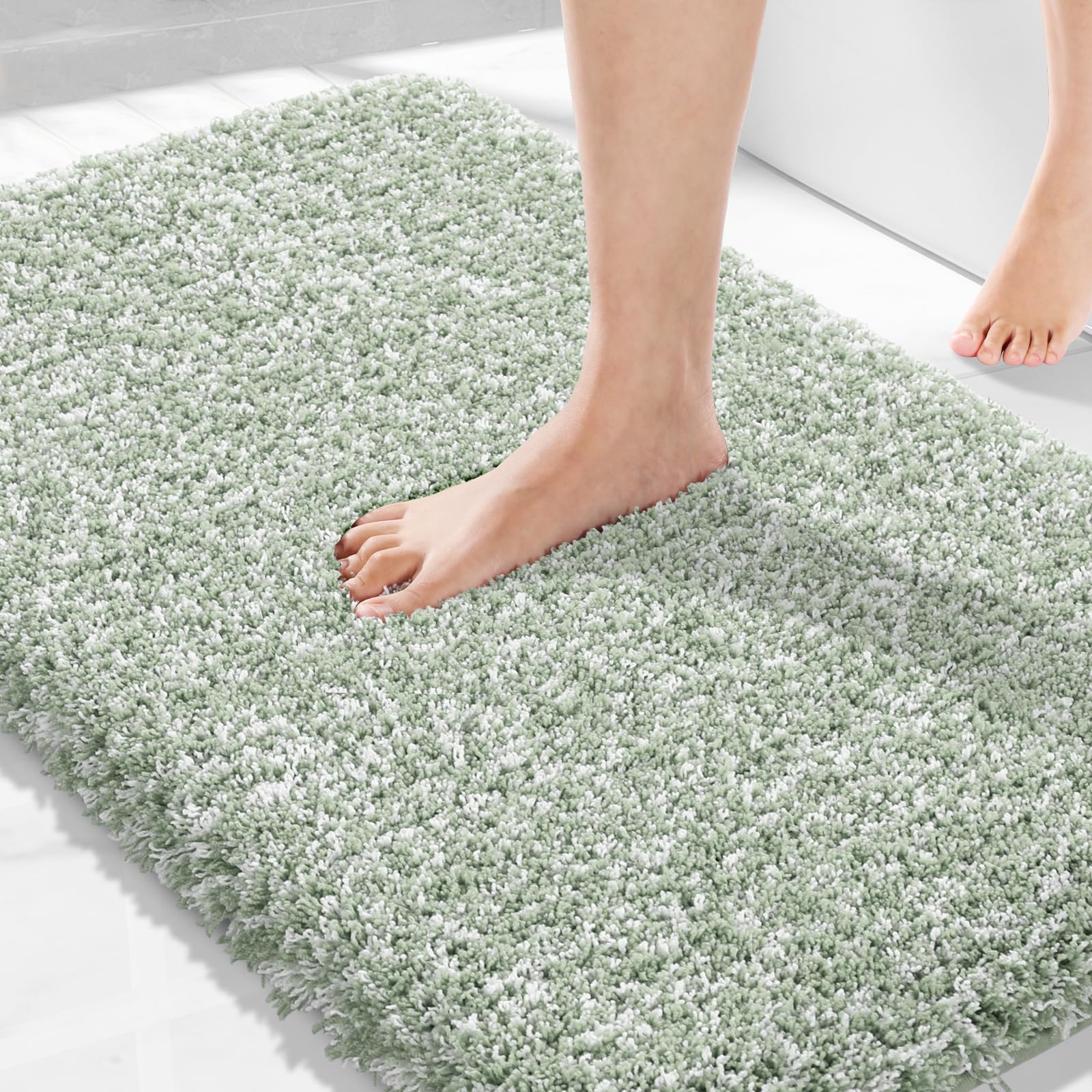 Yimobra light green and white bathroom rug on floor, plush and absorbent for quick water pickup.