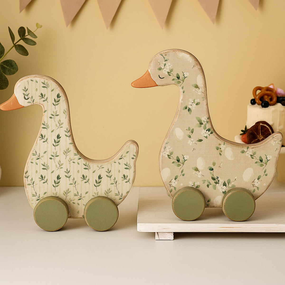 Yousoontic Silly Goose centerpiece with green foliage enhances 1st birthday decor.