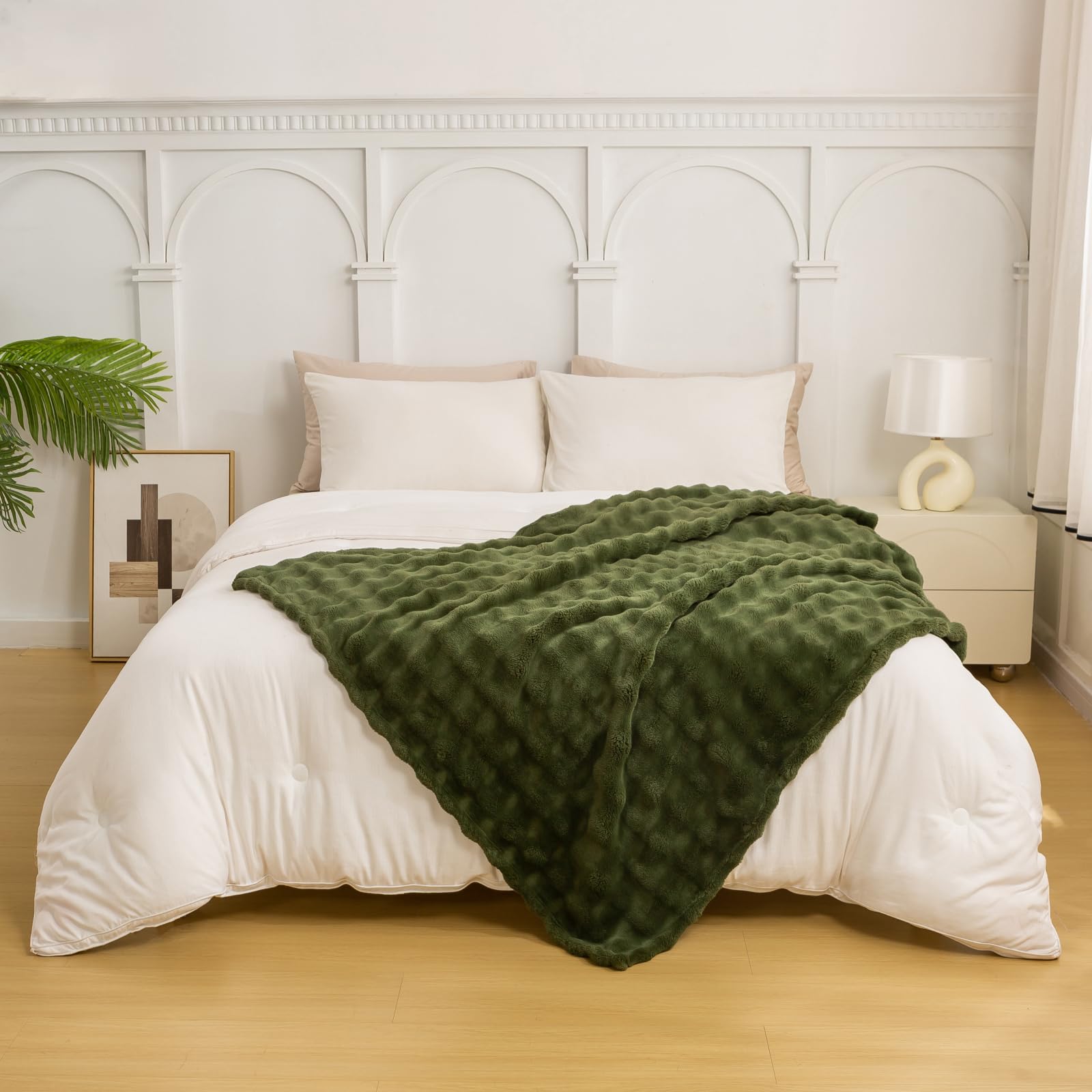 Olive green YUSOKI blanket folded neatly on a bed as warm bedding.