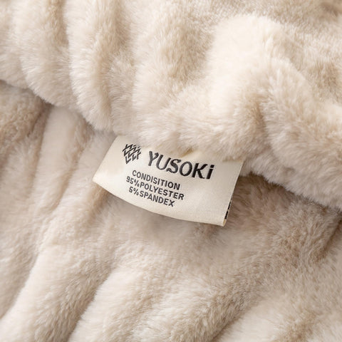 YUSOKI blanket beside fireplace radiates luxury and warmth.